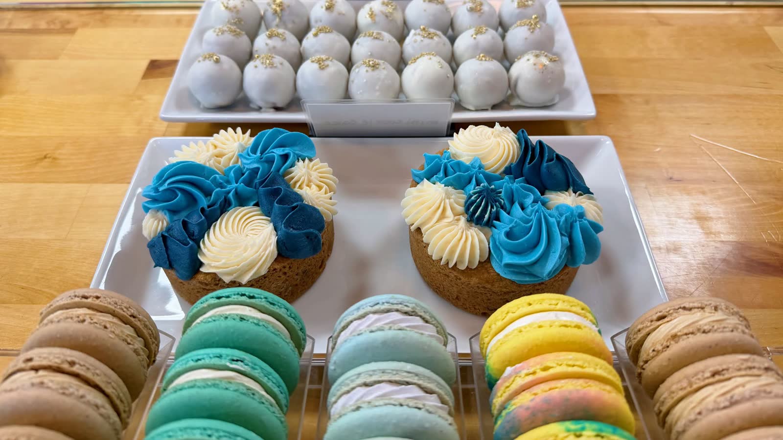 Assorted catering dessert spread with cake bites, cakes and macarons
