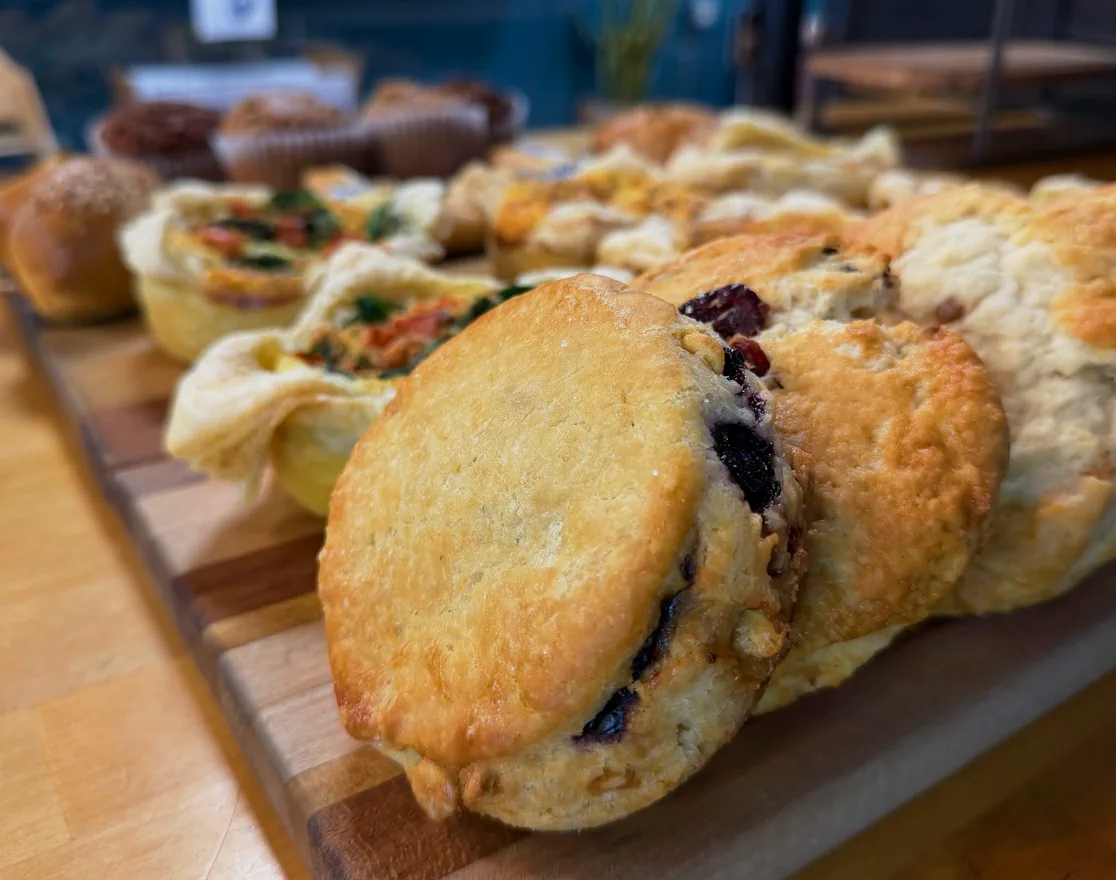 Fresh scones, quiche and muffins on a wooden board